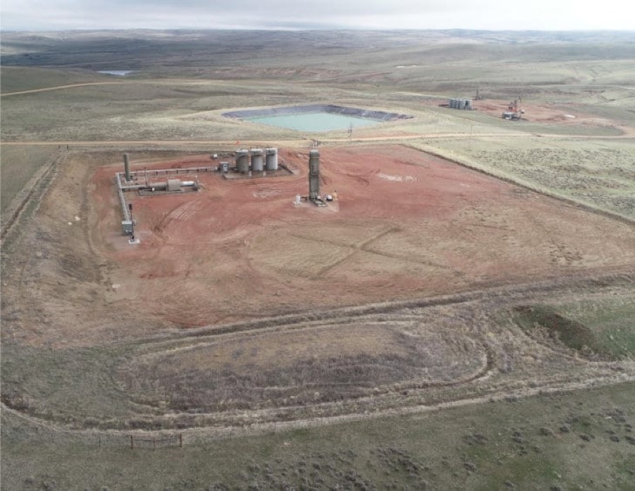 Aerial view of a completed Wyoming well pad with tank battery, access road and lined water pit