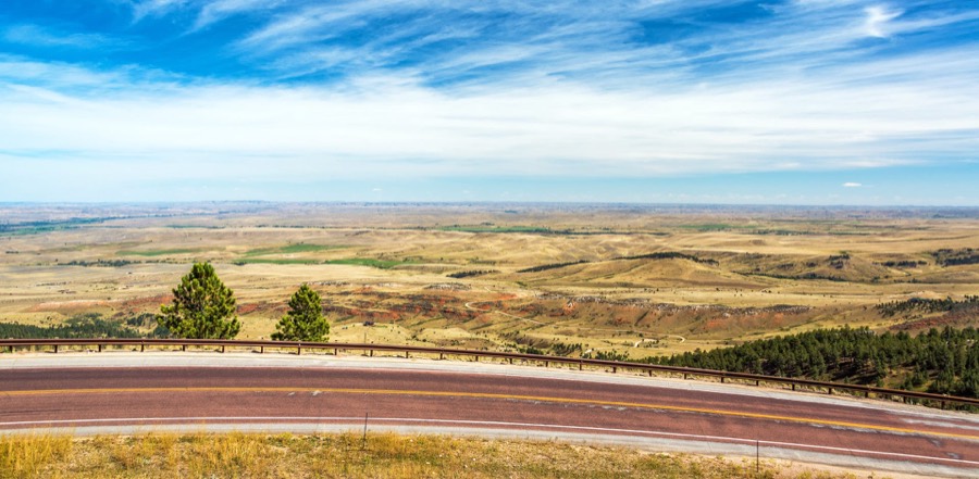 A highway curving above the Sheridan valley with the Wyoming plains stretching to the horizon